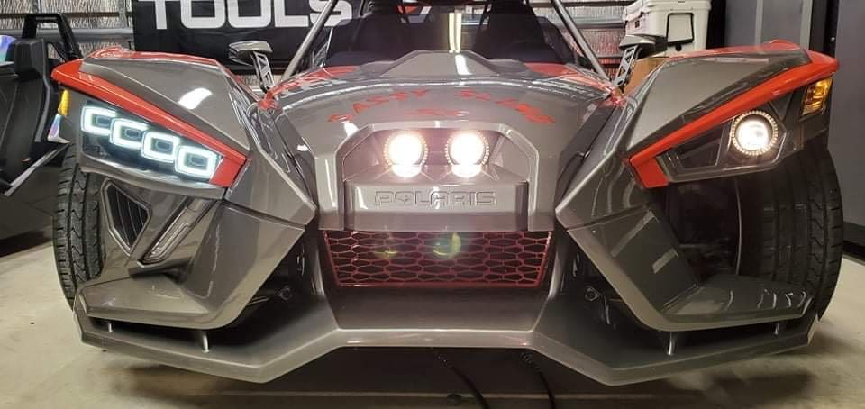 Front view of a sleek Polaris vehicle with modern headlights and sporty design.