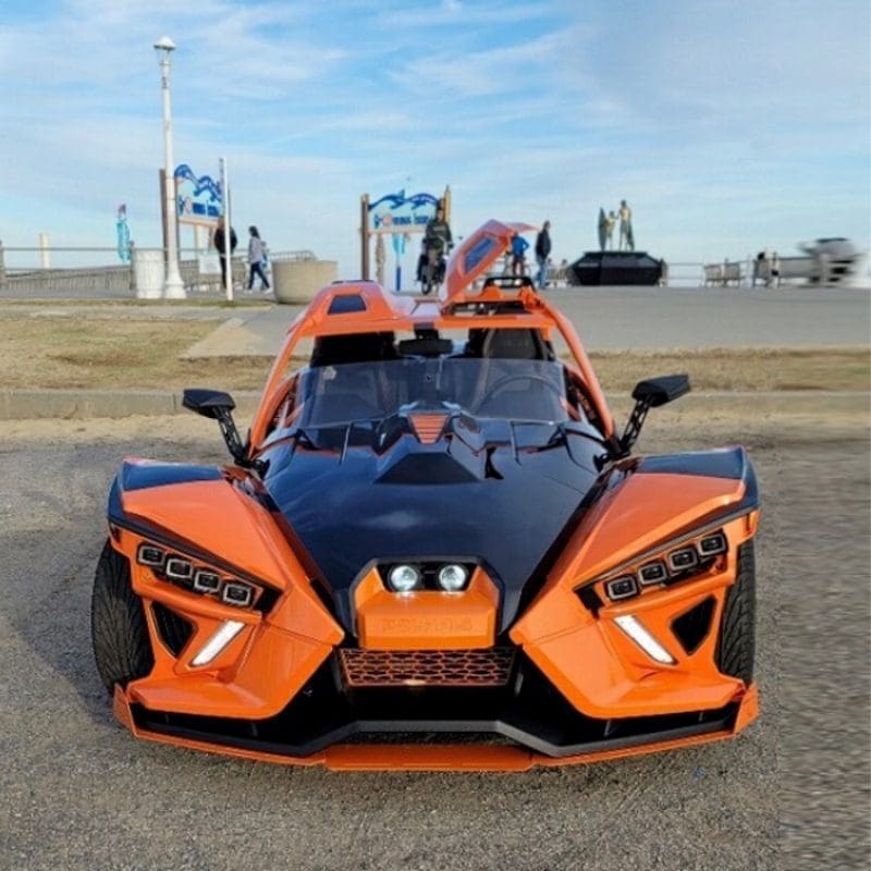 Front view of a sleek orange and black sports car with unique angular design.
