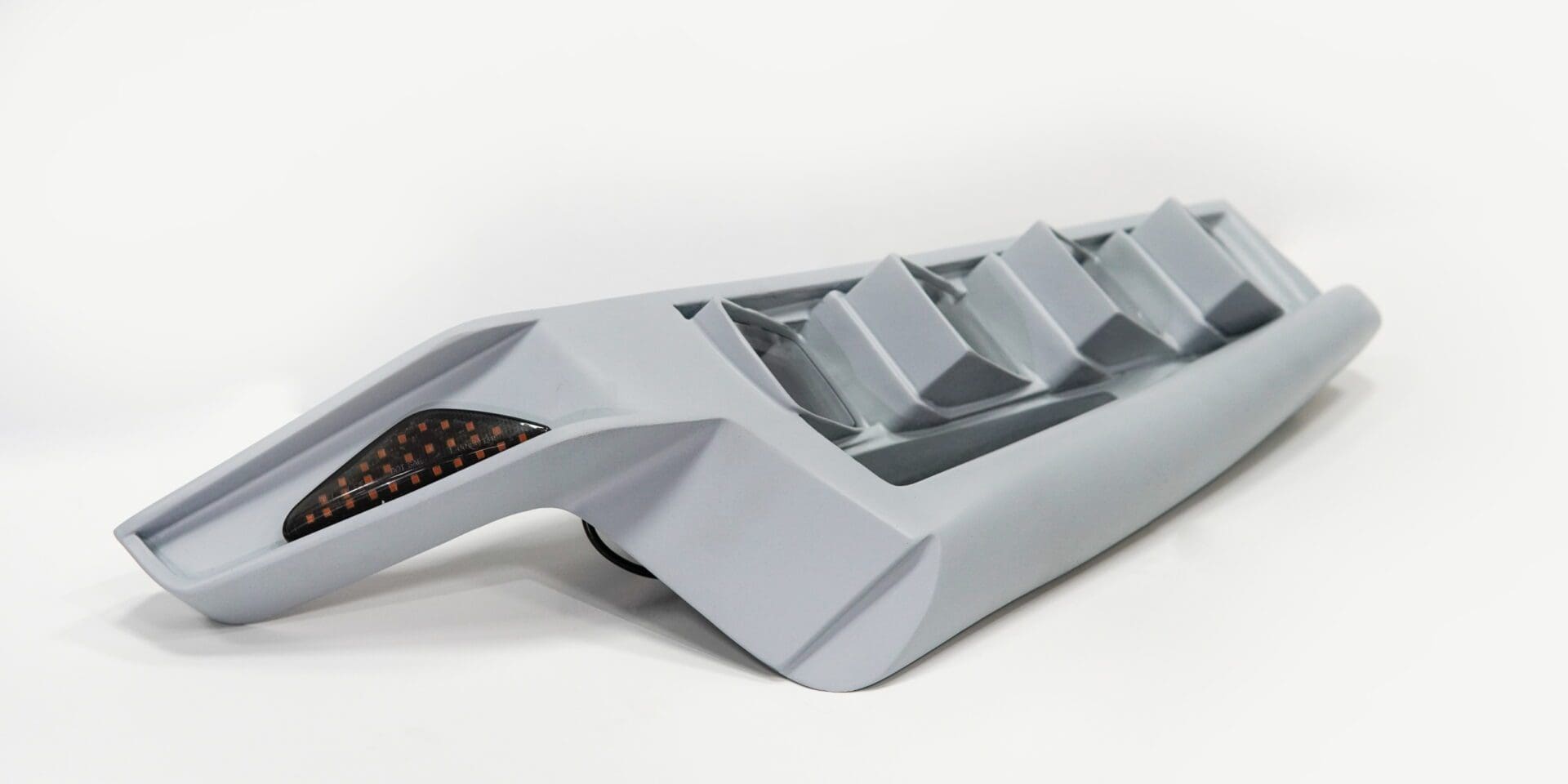 A sleek, modern gray device with angled vents and a dark grille section.
