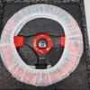 Steering wheel covered with a transparent plastic protective cover.