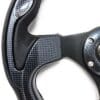 Close-up of a carbon fiber steering wheel with ergonomic grips.