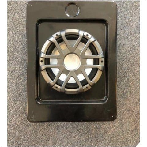 Close-up of a small speaker or tweeter mounted on a black panel.