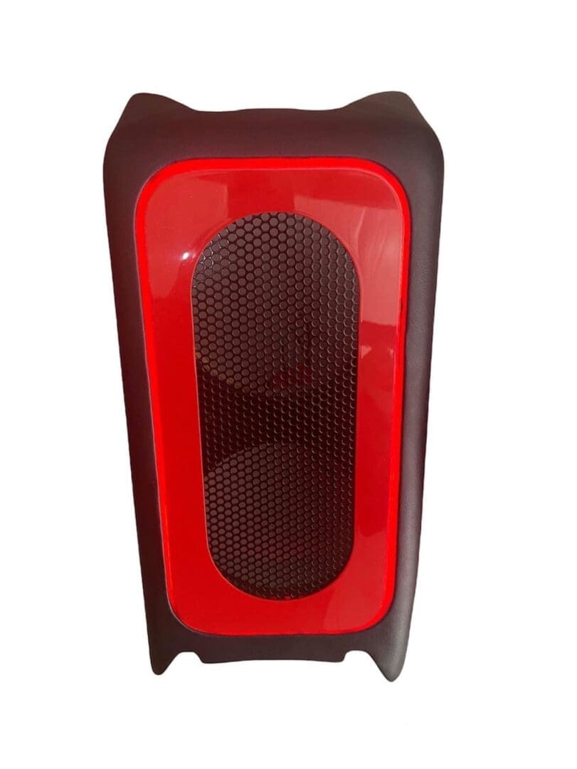 IMG-3120 A modern red and black portable speaker with mesh front.