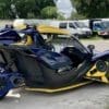 IMG-3207 Sleek three-wheeled vehicle with blue and yellow design.