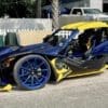 IMG-3208 A customized blue and yellow sports car with unique wheels and a sleek design.