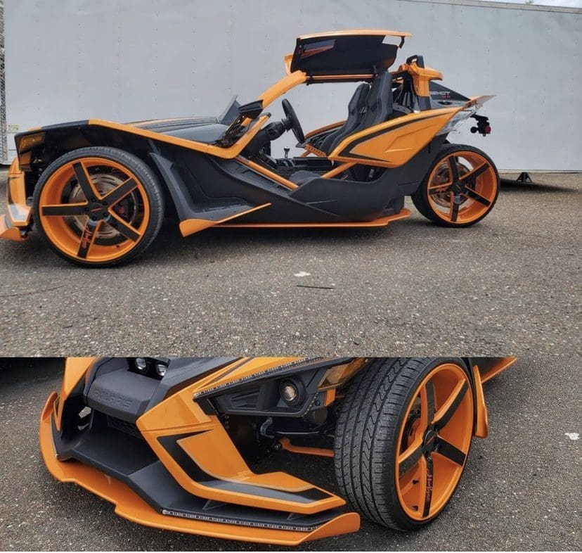 IMG-3211 Sleek black and orange three-wheeled sports car with futuristic design.