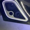 Close-up of a car door panel with illuminated speaker grills.