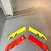 spliters Four colorful plastic car spoiler parts on the floor.