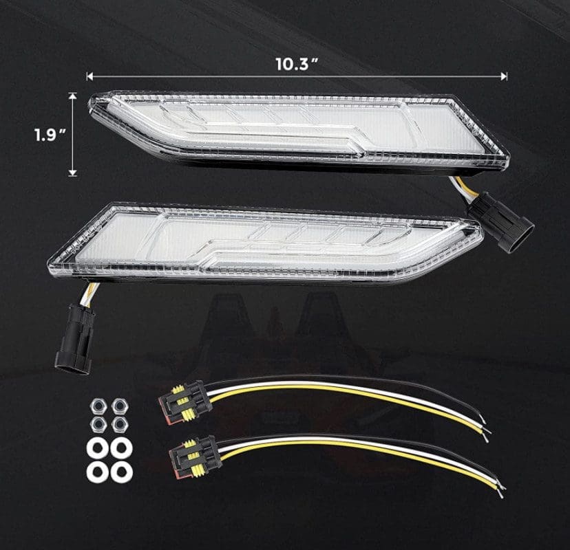 IMG_4138 Pair of clear LED car lights with wiring and mounting hardware on black background.