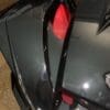 IMG_4371 Close-up of a sleek black sports car's rear with red taillight and aerodynamic design.