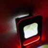 A black device with red and white LED lights glowing in the dark.