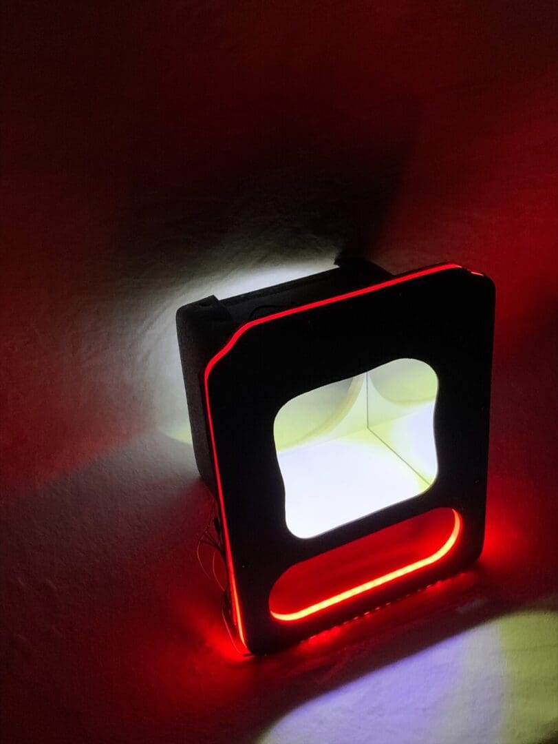 A black device with red and white LED lights glowing in the dark.