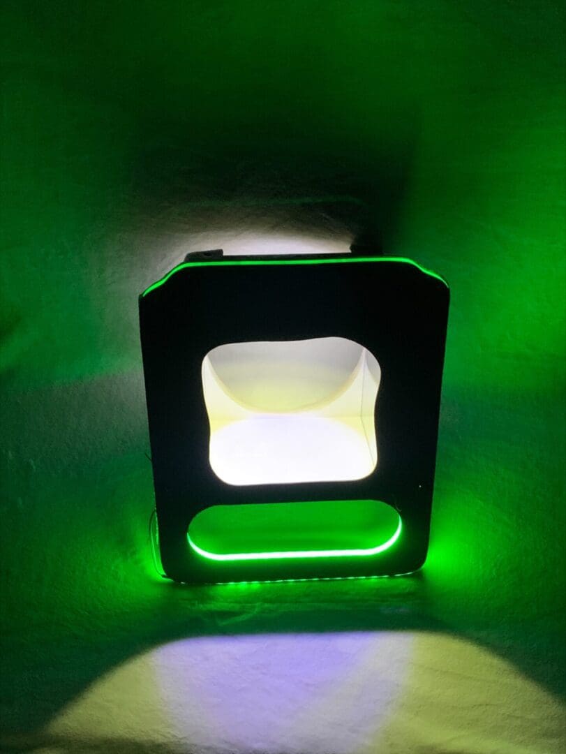 A glowing green and white light box in a dark space.