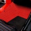 Close-up of a car's red and black carpeted floor mat.