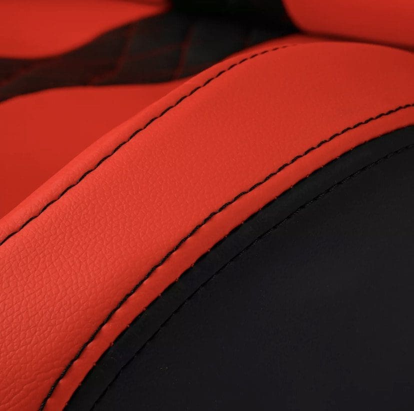 IMG_4961 Close-up of red and black leather upholstery with detailed stitching.