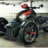 IMG_5302 A sleek black three-wheeled motorcycle with red accents and a shark-face design.