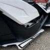 Close-up of a white and black motorcycle body part with detailed design.