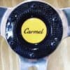 IMG_6973 Close-up of a car steering wheel center with 'Carmel' logo.