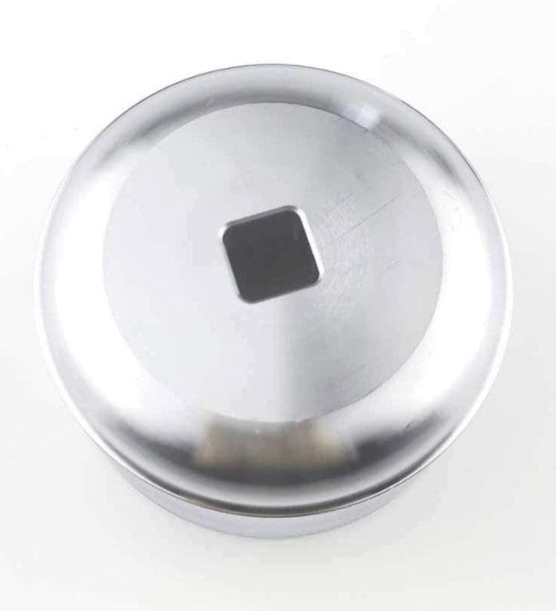 IMG_7014 Metallic round object with a square hole in the center on a white background.