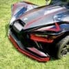IMG_7275 Close-up of a sleek black sports car with red accents on grass.