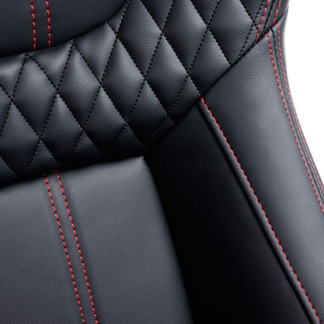5ea1bc7b-0c80-4b16-a17f-d9dd8be00461 Close-up of black leather car seat with red stitching.