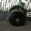 image_b0ba6b23-47bb-4fb5-989c-95098a356d91 Black round speaker or audio component on a dark surface.