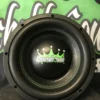 image_f08312b6-42ea-47f8-a07e-83e85865617d Close-up of a black subwoofer speaker with a green crown logo.