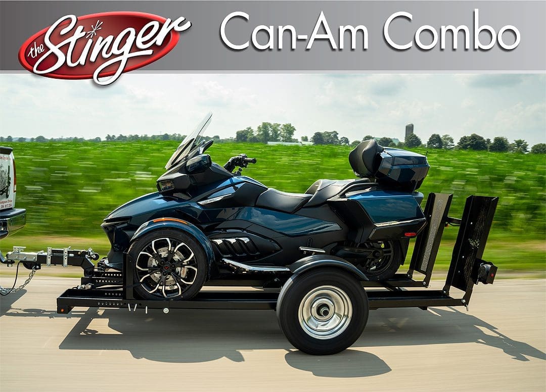 A Can-Am Spyder on a trailer in a rural area.