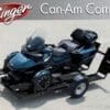 A blue Can-Am Spyder motorcycle on a trailer ready for transport.