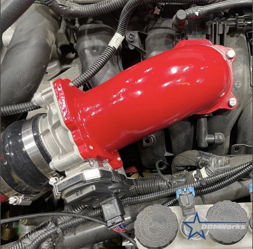 IMG-1697 Bright red silicone intake hose installed in a car engine bay.