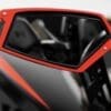 IMG-1700 Close-up of a red side mirror on a vehicle showing part of the interior.