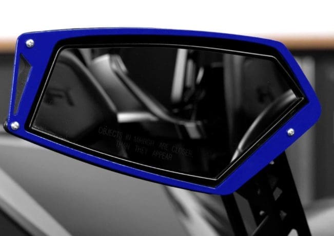 IMG-1703 (1) Close-up of a sleek blue car side mirror reflecting the interior.