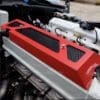 Close-up of a red engine cover with black vents.