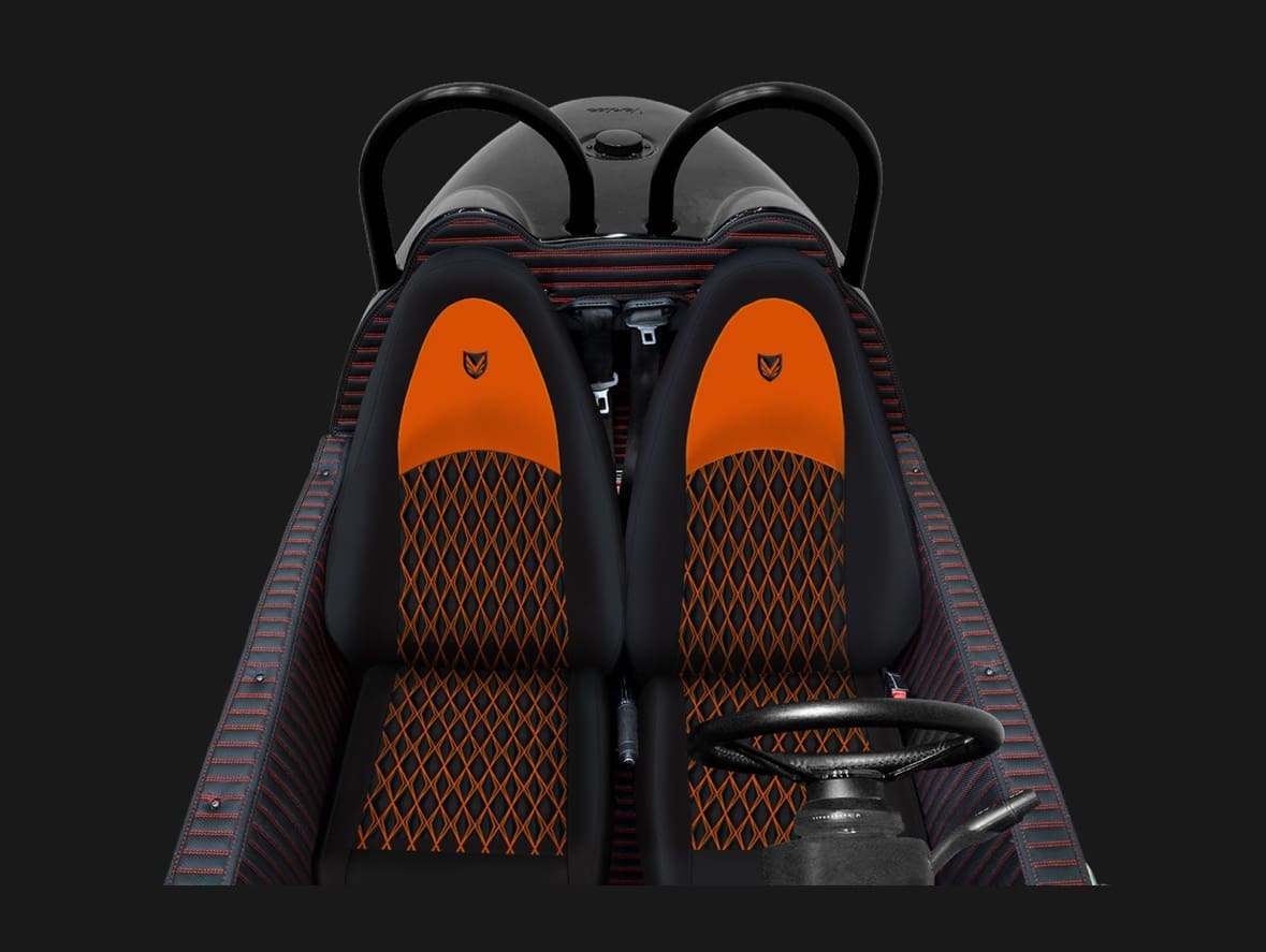 Top-down view of a two-seater vehicle with orange and black seats.