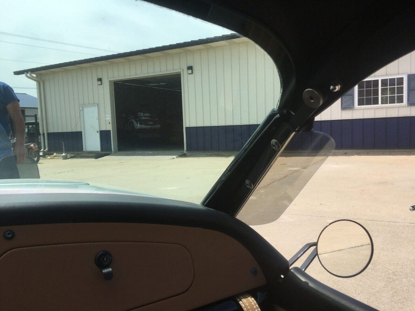 s-l1600 (11) View from inside a vehicle looking out at a building with an open garage door.