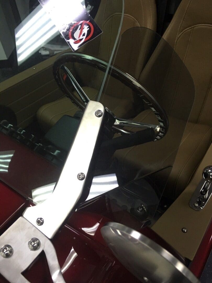 Close-up of a red toy tractor with a white seat and steering wheel.