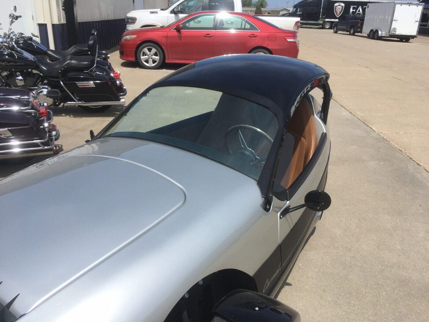 s-l1600 (5) A silver convertible car with a black soft top roof parked outdoors.