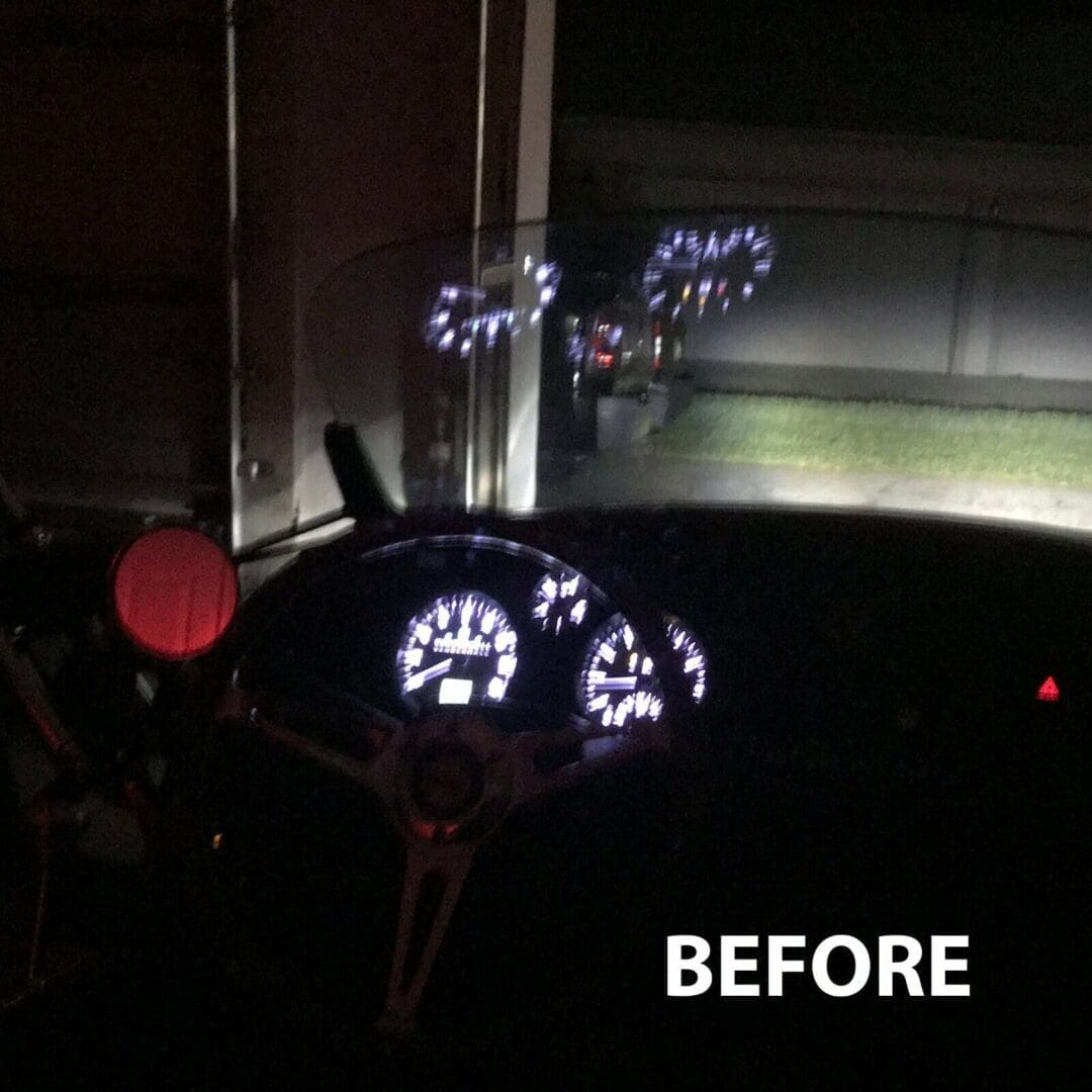 Car dashboard display before modifications in a dark setting.
