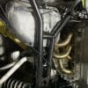 Close-up of a car engine's exhaust manifold and suspension components.