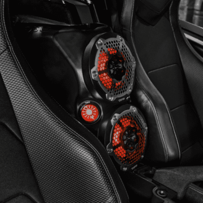 Close-up of a car interior with red-accented gauges on a carbon fiber panel.