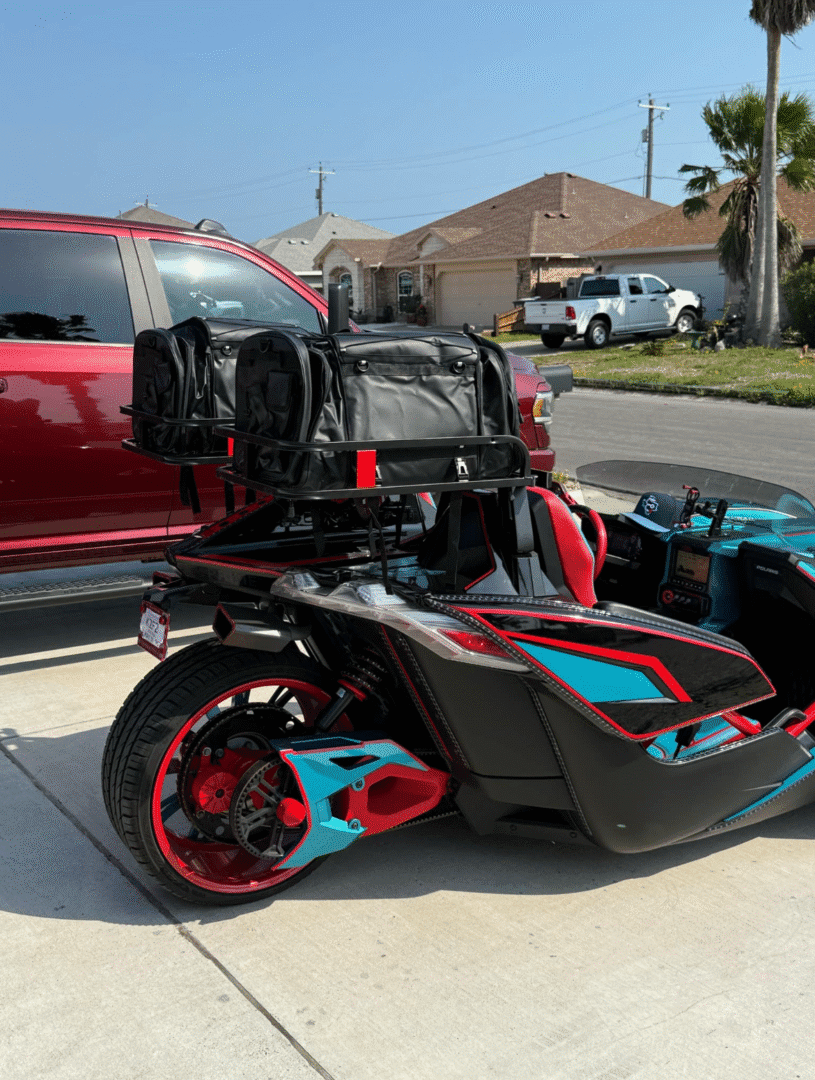 Custom three-wheeled motorcycle with vibrant red and turquoise accents.