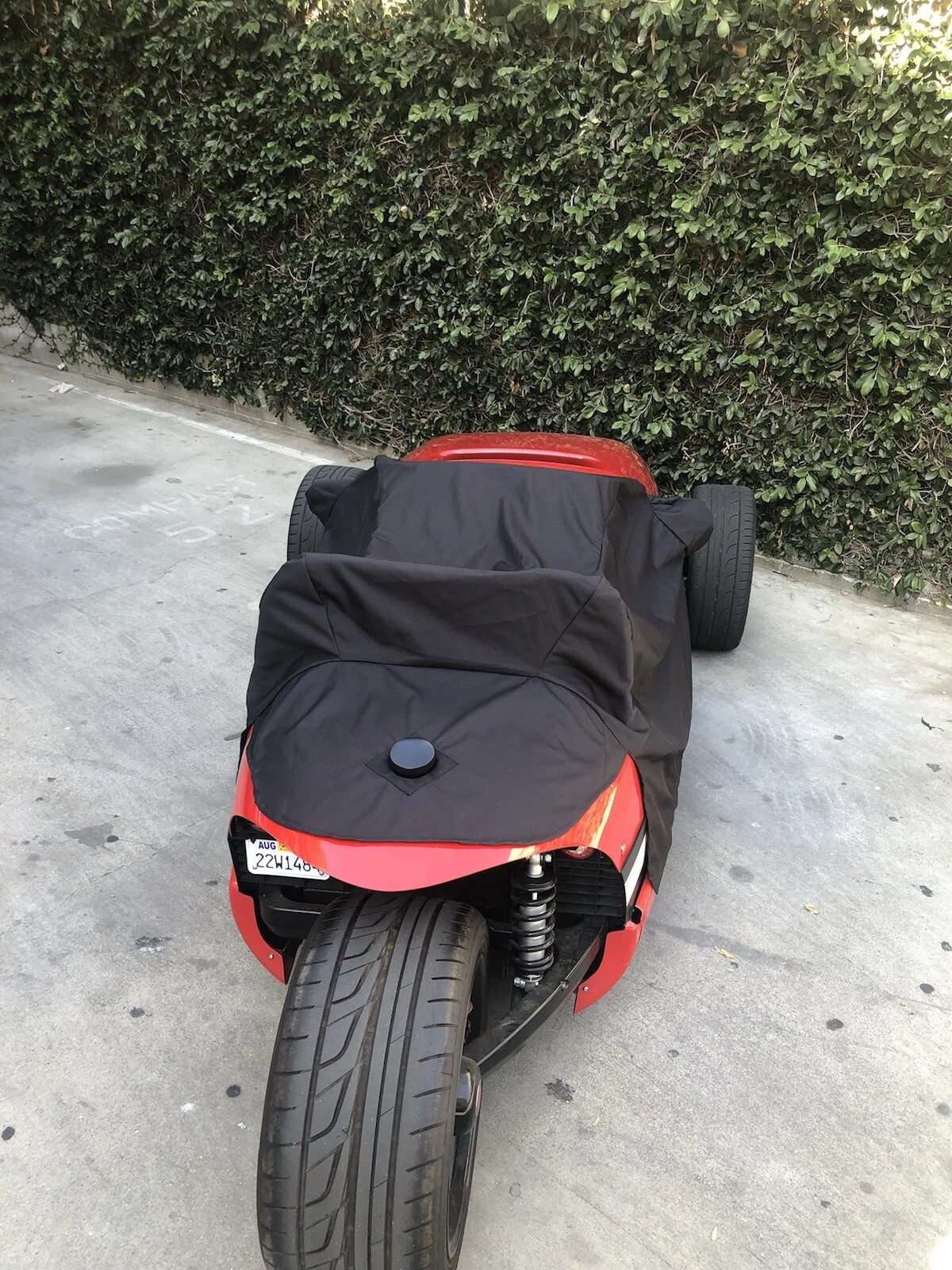 s-l1603 A black and red motorcycle covered with a black protective sheet.