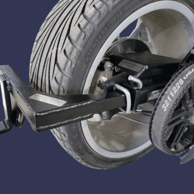 Close-up of a wheel alignment tool attached to a car tire.